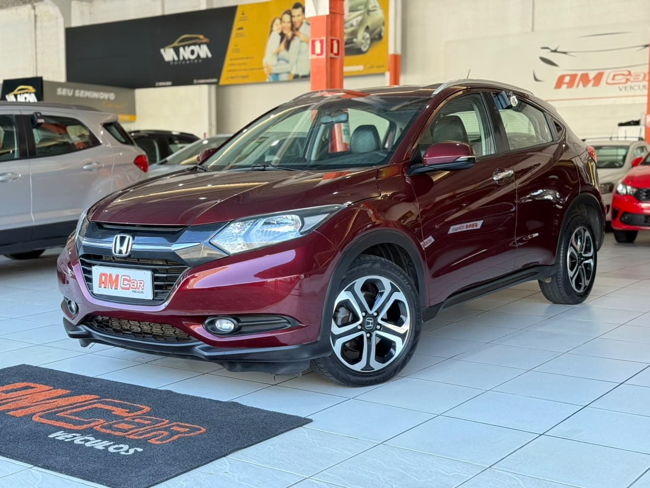 Honda HR-V vinho visto de três quartos dianteiro, no showroom da AMCar