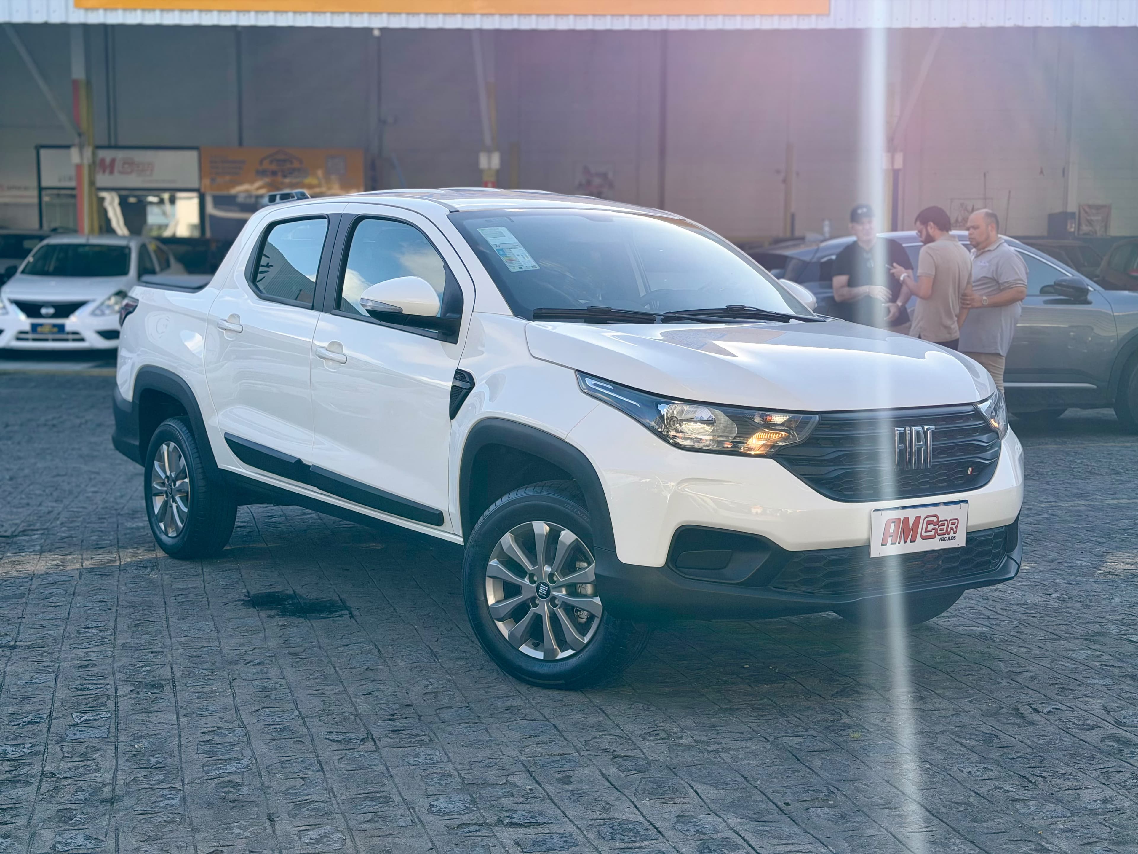 Fiat Strada Freedom branca, vista frontal 3/4, exposta na loja