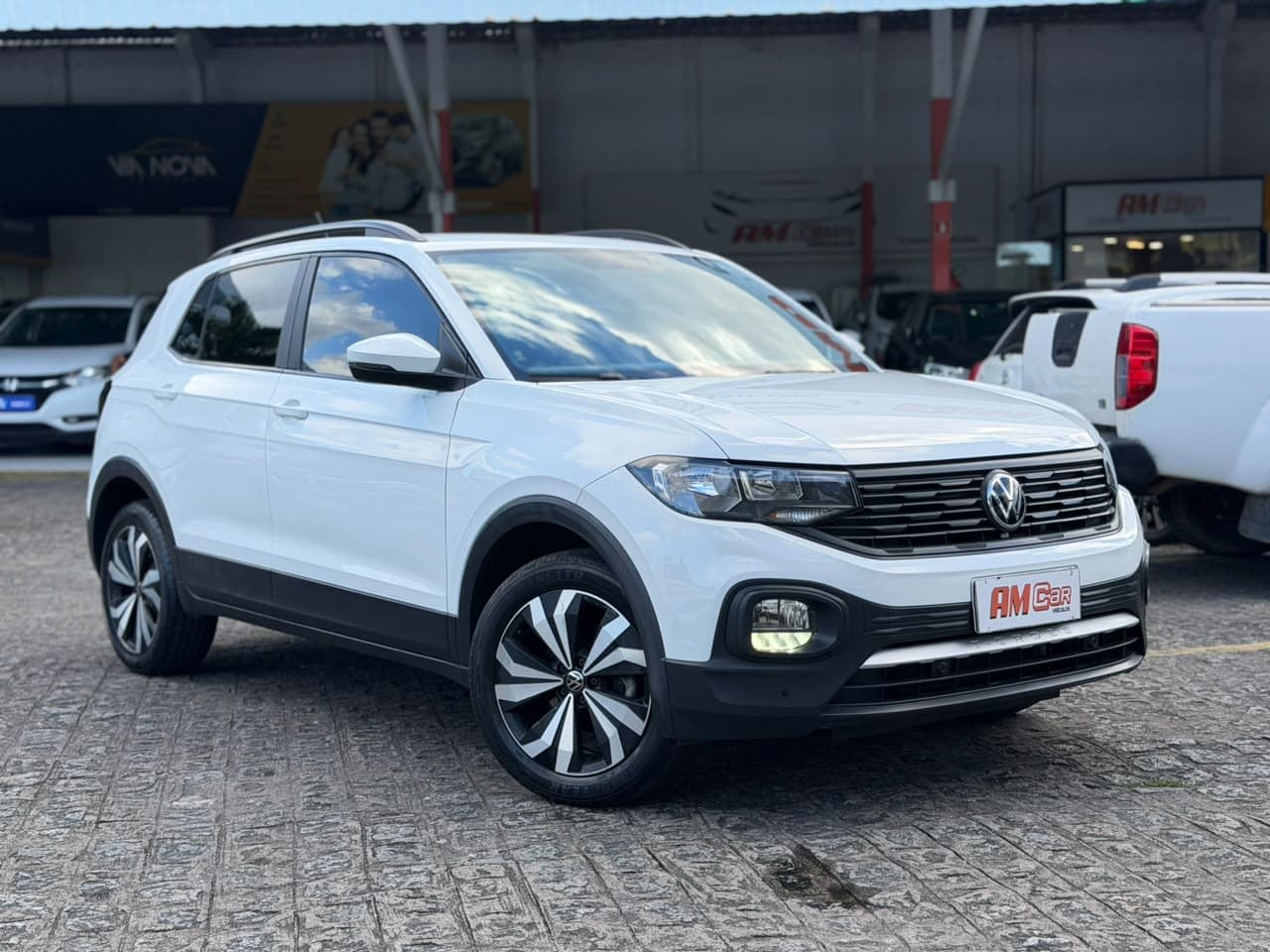 Volkswagen T-Cross TSI Premium branca, vista frontal 3/4, exposta na loja